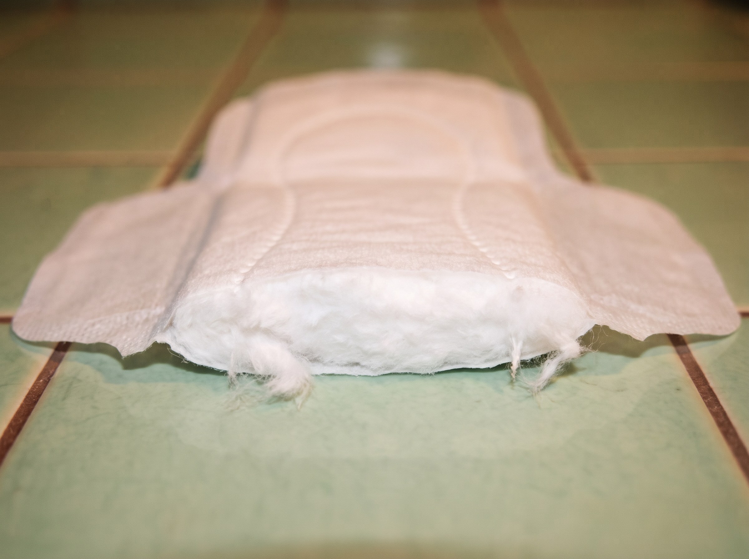 A Garnuu pad cut open: soft white organic cotton from the top sheet through the whole core
